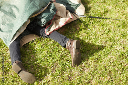 Camping disaster. Cropped view of a mans legs while trapped beneath a tent.