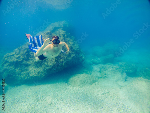 man with greece flag swimming underwater