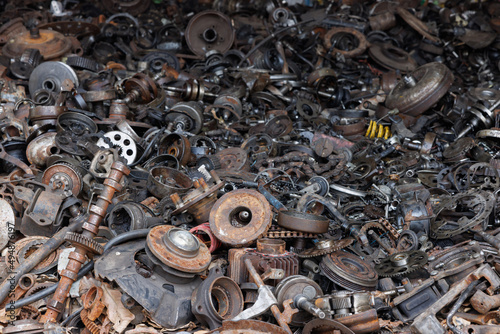 a pile of waste automotive parts in recycle factory. scrap metal - predominantly ferrous metals. Waste from industry and household. recycle factory. scrap metal - predominantly ferrous metals.