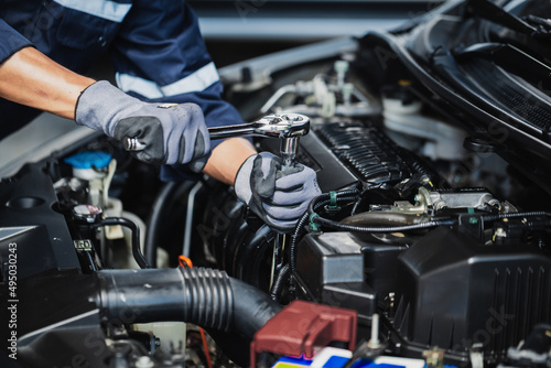 Professional mechanic working on the engine of the car in the garage. Car repair service.