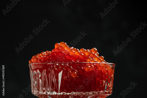 delicious red caviar on a black background. Gourmet food close up, appetizer, selective focus, place for text
