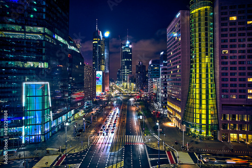 Beautiful panoramic aerial drone skyline view of the center of night Warsaw with skyscrapers in the background on avenues of John Paul II - the lights of the big city by night, Poland, EU