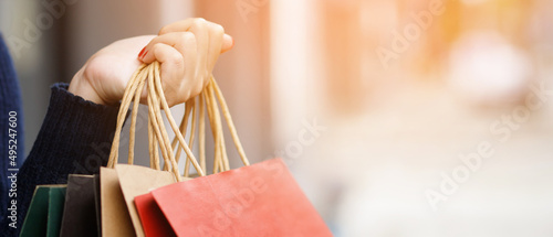 Close up of consumerism young woman holding hand many shopping bag in fashion boutique after buying presents while walking along the street with copy space , enjoying summer sale and people concept