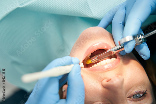 Woman receiving dental treatment in stomatology clinic