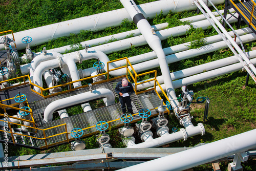 Top view male worker inspection at valve of visual check record pipeline oil