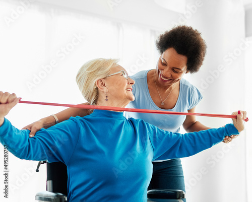 senior care exercise physical therapy exercising help assistence retirement home physiotherapy physiotherapist fitness gym strech band clinic therapist elderly woman band stretching