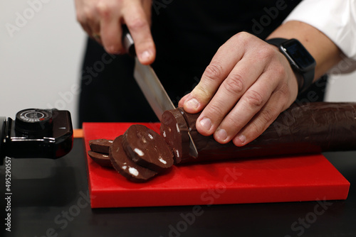 carnicero cortando barra de embutido con cuchillo grande