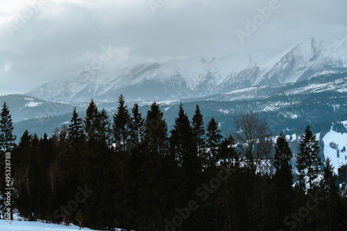 Tatry Wysokie o świcie, zima, szczyty w chmurach, Karpaty, widok z przełęczy nad Łapszanką.