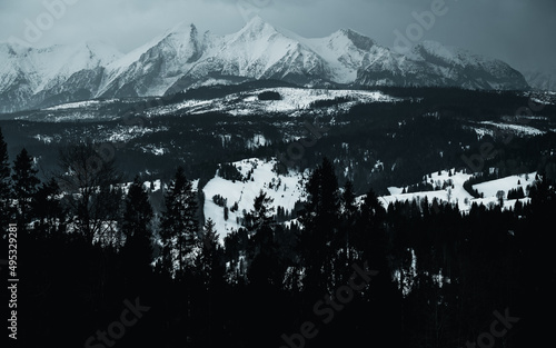 Tatry Wysokie o świcie, zima, szczyty w chmurach, Karpaty, widok z przełęczy nad Łapszanką.