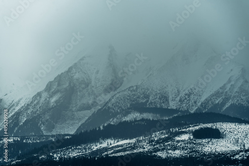 Tatry Wysokie o świcie, zima, szczyty w chmurach, Karpaty, widok z przełęczy nad Łapszanką.