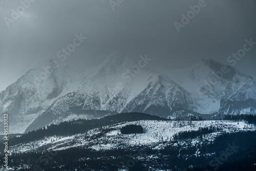 Tatry Wysokie o świcie, zima, szczyty w chmurach, Karpaty, widok z przełęczy nad Łapszanką.