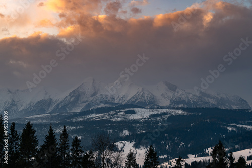 Tatry Wysokie o świcie, zima, szczyty w chmurach, Karpaty, widok z przełęczy nad Łapszanką.