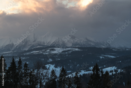 Tatry Wysokie o świcie, zima, szczyty w chmurach, Karpaty, widok z przełęczy nad Łapszanką.