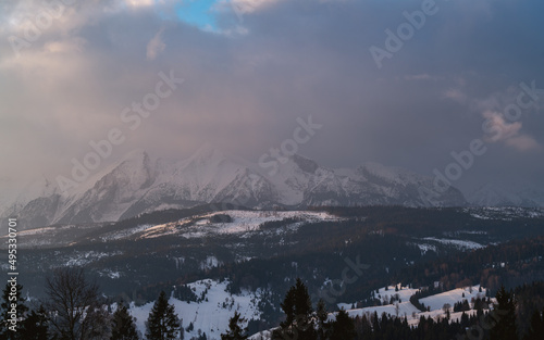 Tatry Wysokie o świcie, zima, szczyty w chmurach, Karpaty, widok z przełęczy nad Łapszanką.