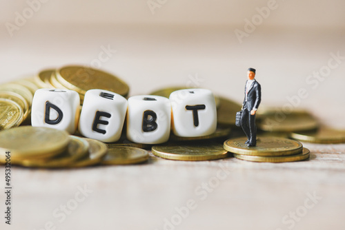 Block word debt on pile of coins with business man, Payment of taxes and of debt to the state, Concept of financial crisis and problems risk management debt exemption loan