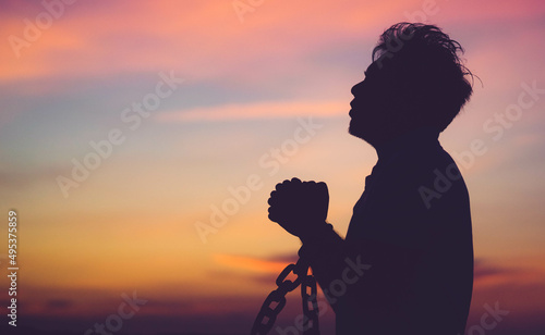 Silhouette man with chain Freedom, Worship and Pray.Repent of wrong doing.Prisoner with break chain power of prayer sunset background.Pray faith hope.Forgive revival.Sacrifice and Mercy.Man repent sin