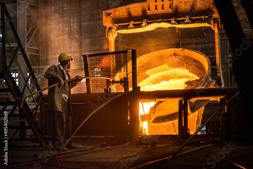 Steelworker at work near the tanks with hot metal