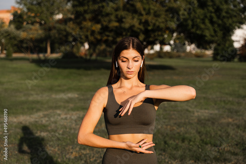 Hand movement of qigong meditation. Attractive girl meditating in the green park.