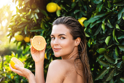 Beautiful woman with smooth skin with a lemon fruit in her hands