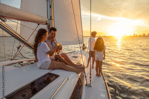 Hispanic family relaxing on luxury yacht at sunset