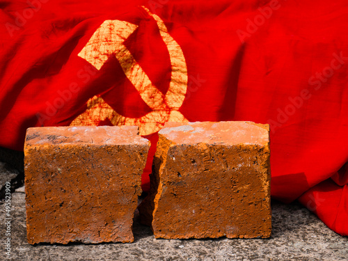 The concept of photo of dissolution of the Soviet Union, the Cold War, NATO, communism, totalitarianism, decommunization. Cracked brick next to the USSR flag 