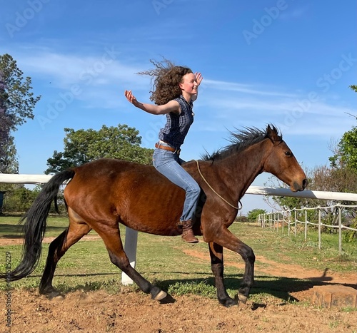 Cowgirl riding horse bareback no hands no tack