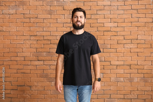 Handsome man in black t-shirt on brick background