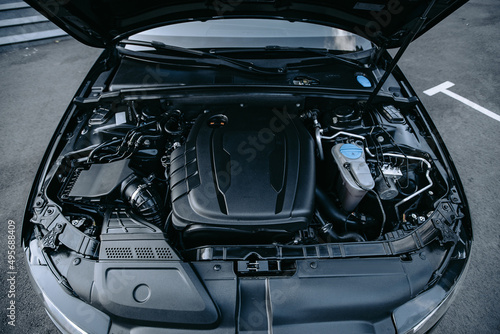 Car with open hood close up to camera. Maintenance in auto repair shop. Car service, repair, maintenance concept. Selective focus.