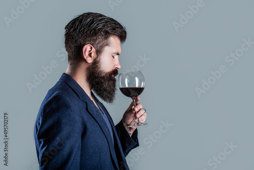 Man with a glass of red wine in his hands. Beard man, bearded, sommelier tasting red wine. Sommelier, degustator with glass of wine, winery, male winemaker