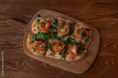 Pizza with salmon on roman dough with ruccola
