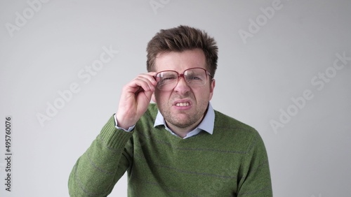 Curious scrupulous man looks attentively at one point, sees something strange or suspicious.