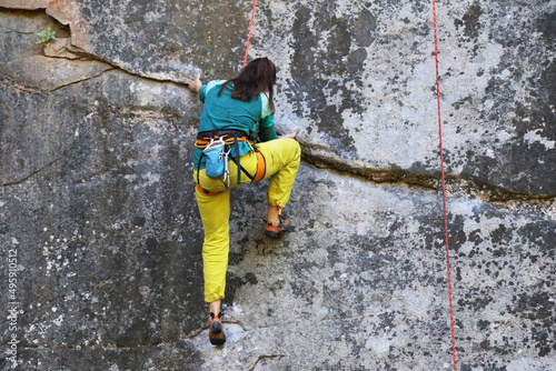 girl climber trains on a sheer cliff