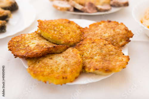 Potato pancakes with sour cream on white plate