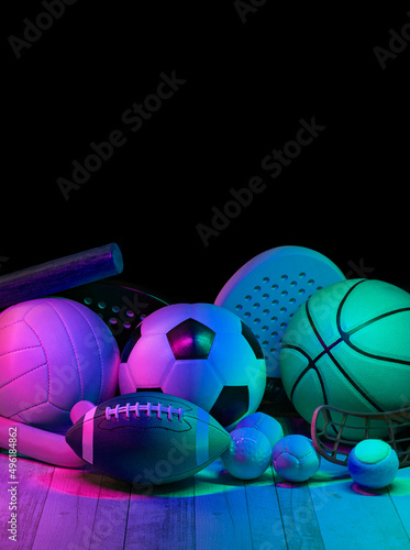 Sports equipment, rackets and balls on hardwood court floor with neon light background. Vertical education and sport poster, greeting cards, headers, website.