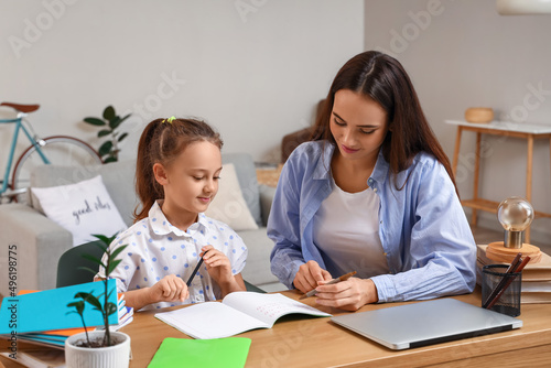 Cute girl studying with tutor at home