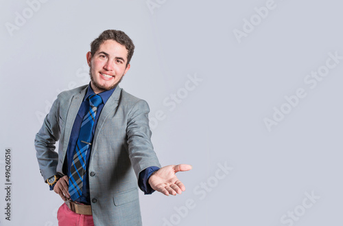 Man extending his hand inviting, man in suit welcoming, man looking at camera presenting a product, person inviting