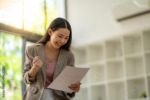 excited business woman reading good news in paper letter She was promoted and received an additional yearly bonus.