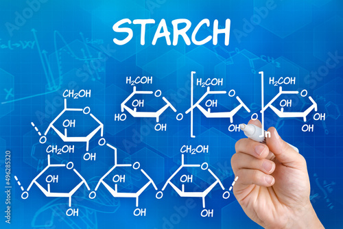 Hand with pen drawing the chemical formula of starch