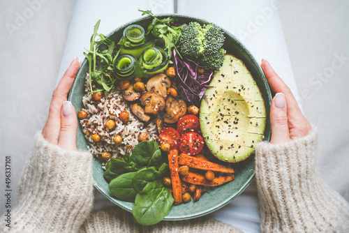 Woman holding plate with vegan or vegetarian food. Healthy plant based diet. Healthy dinner or lunch. Buddha bowl with fresh vegetables. Healthy eating