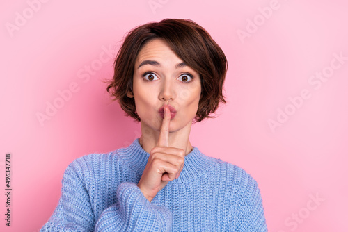 Portrait of charming funky lady staring camera cover mouth with finger ask to be silent isolated on pink color background