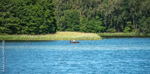 Fischer sitzt im Boot und angelt auf dem See.