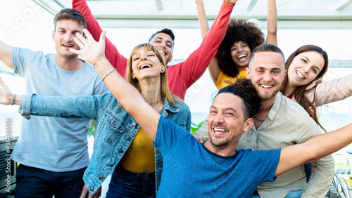 Group of multiracial people with hands up smiling at camera together - Corporate team colleagues congratulating coworker with business success in coworking shared office