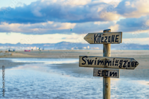Kitezone and swimmingzone sign at beach.