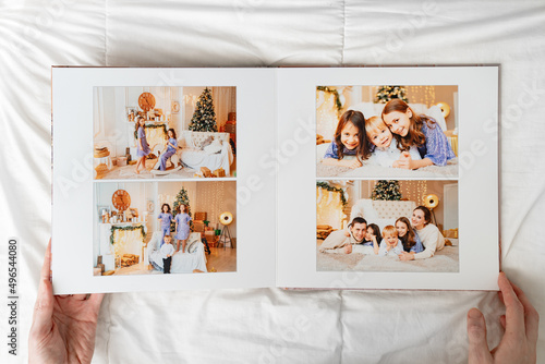 hands with opened photobook on a white background. family photo shoot 