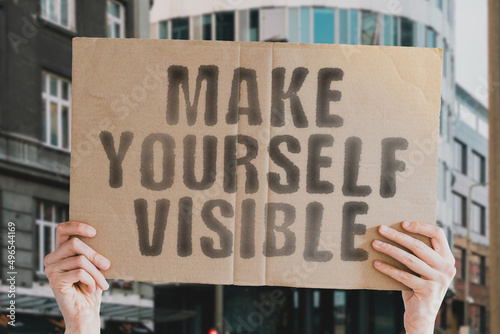 The phrase " Make yourself visible " on a banner in men's hands with blurred background. Share. Skill. Story. Storytelling. Strategy. Career. School. Procedure. Telling. Thinking. Vision. Plan. Future