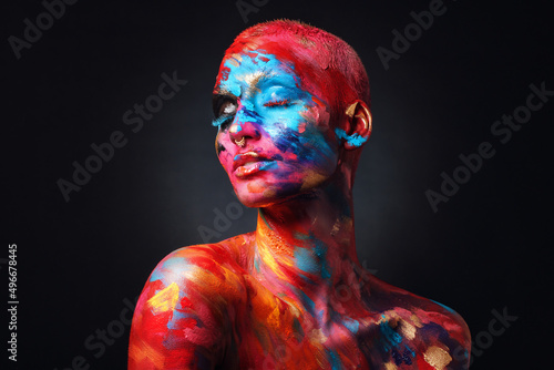 I feel complete in my art world. Shot of an attractive young woman posing alone in the studio with paint on her face and body.