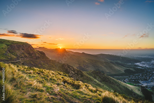 Beautiful landscape view of green mountains with a cloudy sky at sunset in Christchurch, New Zealand