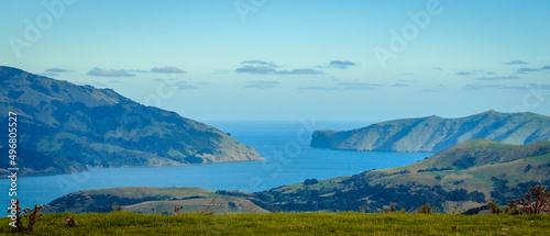 Mesmerizing view of the sea with mountains against a cloudy sky in Akaroa, Christchurch, New Zealand