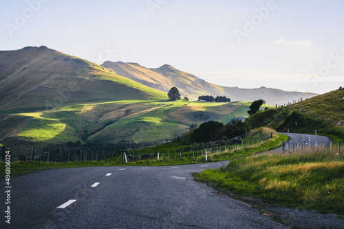 Long rural road leading to the mountains in Akaroa, New Zealand