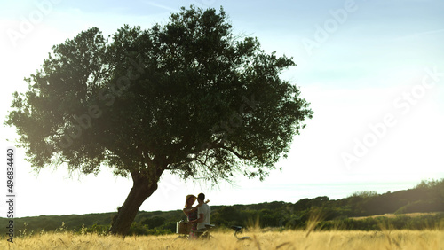 Romantic couple hugging standing near tree in fields